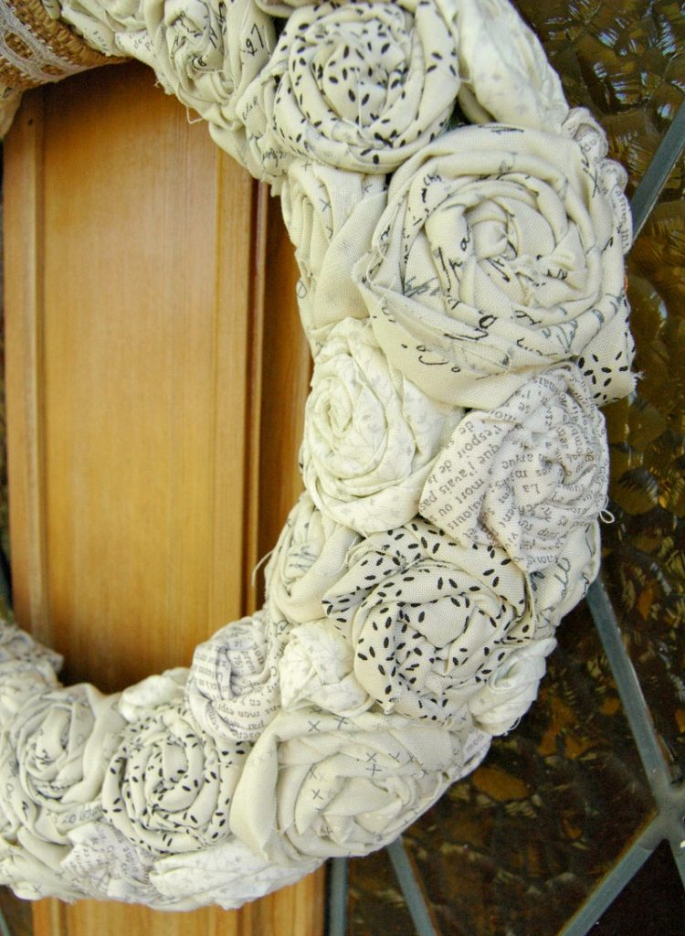 I love the neutral colors, the contrast in fabric patterns and the overall texture of this rolled fabric rose farmhouse wreath!