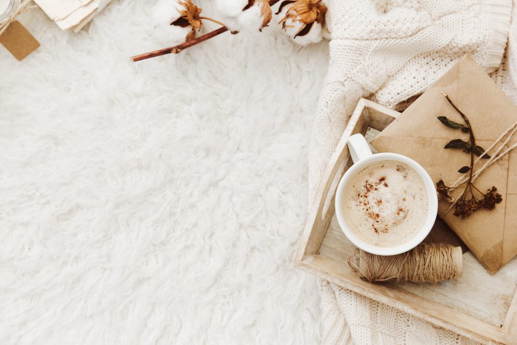 Winter cozy background with cup of coffee, warm sweater and old letters
