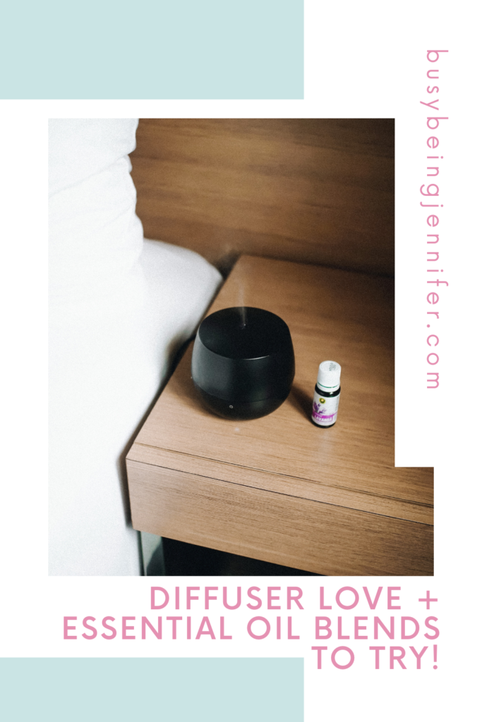 Black essential oil diffuser on night stand with single essential oil next to it. Text overlay that reads: Diffuser Love + Essential Oil Blends to Try!